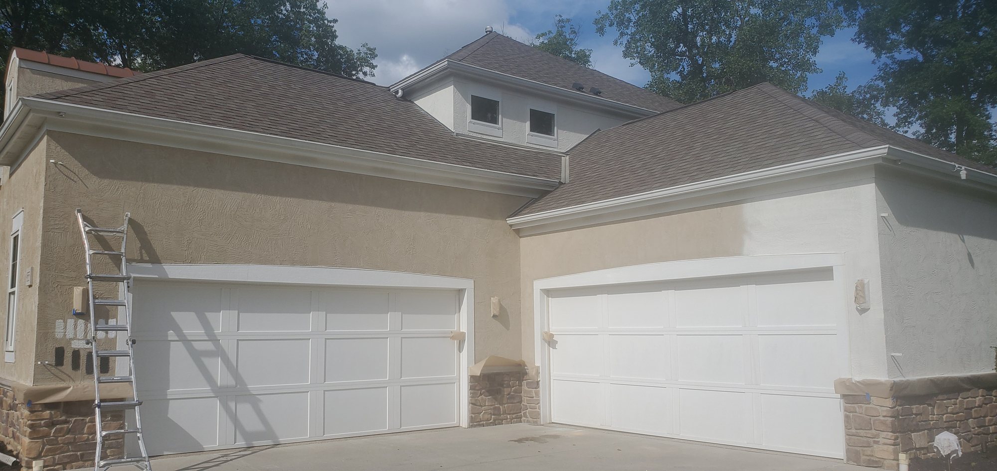 Stucco house garage doors painting in progress — Segor Painting, Columbus OH